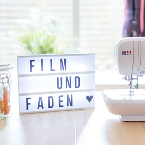 Film und Faden in einer Lichtbox neben Nähmaschine